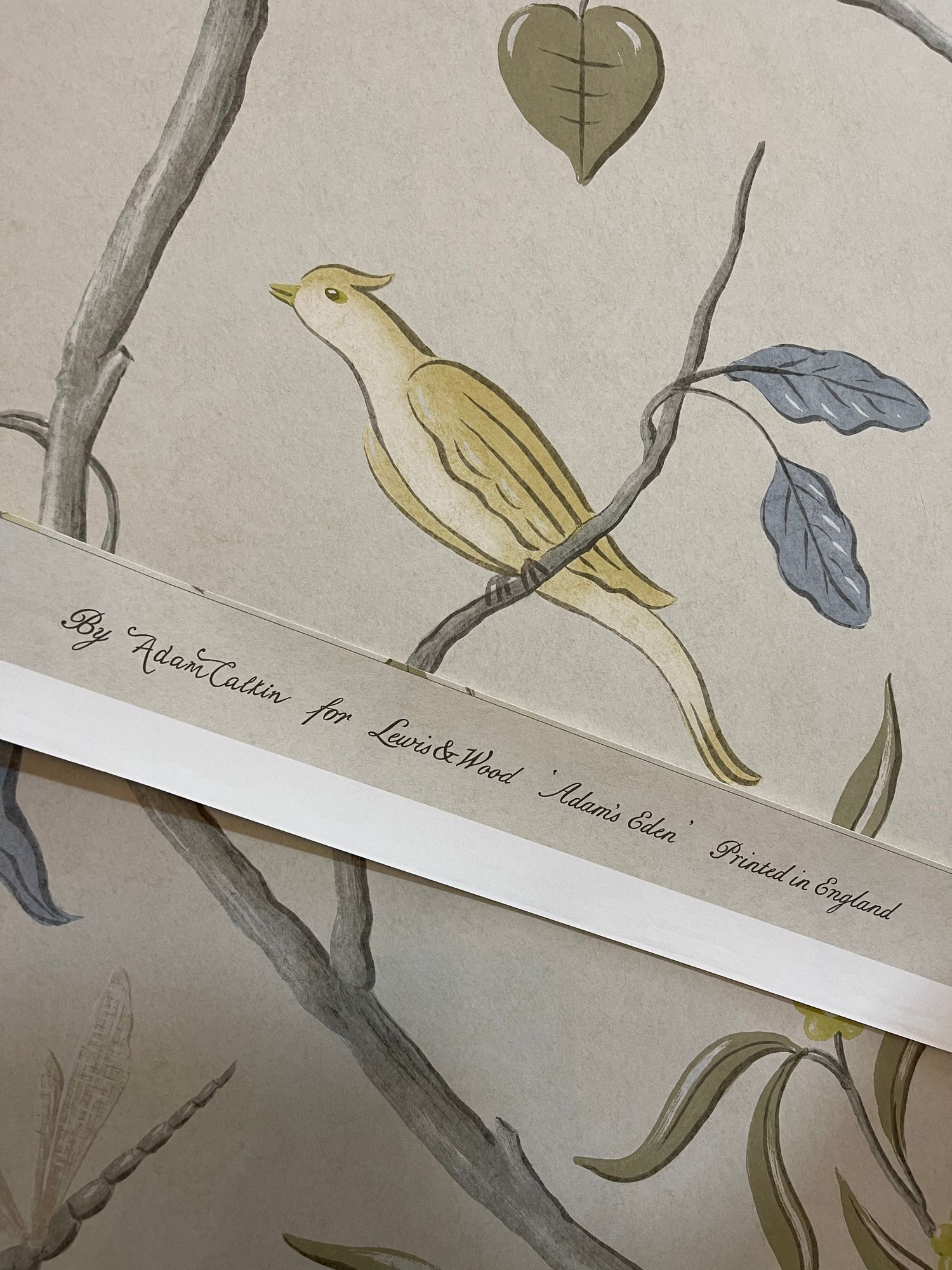 Close view of Adam's Eden wallcovering by Adam Calkin for Lewis & Wood at Brown's Hotel, Mayfair: a yellow bird on a branch above the printed selvedge.