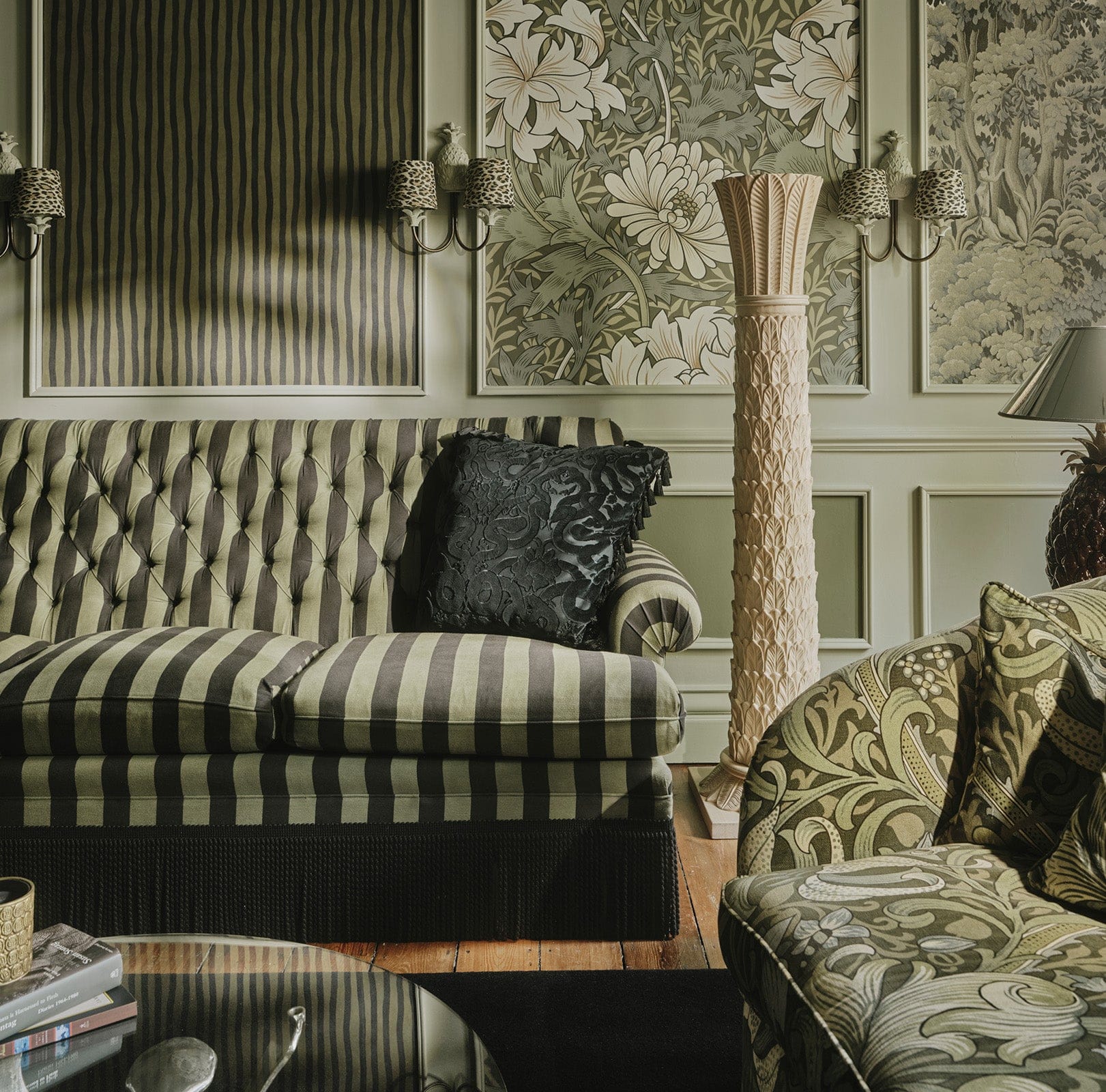 Panelled wall with floral and striped wallpaper behind a striped sofa at the House of Hackney showroom.