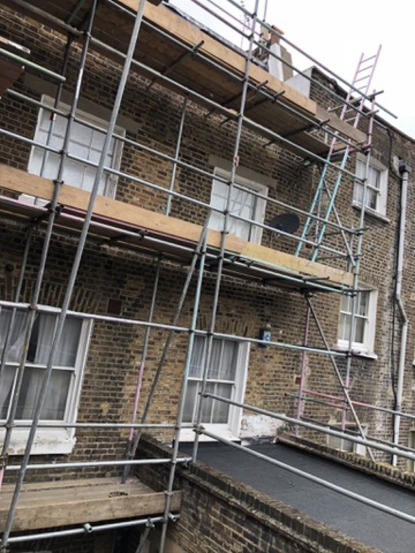 Rear brick elevation on Inverness Terrace, seen from above, under scaffold.