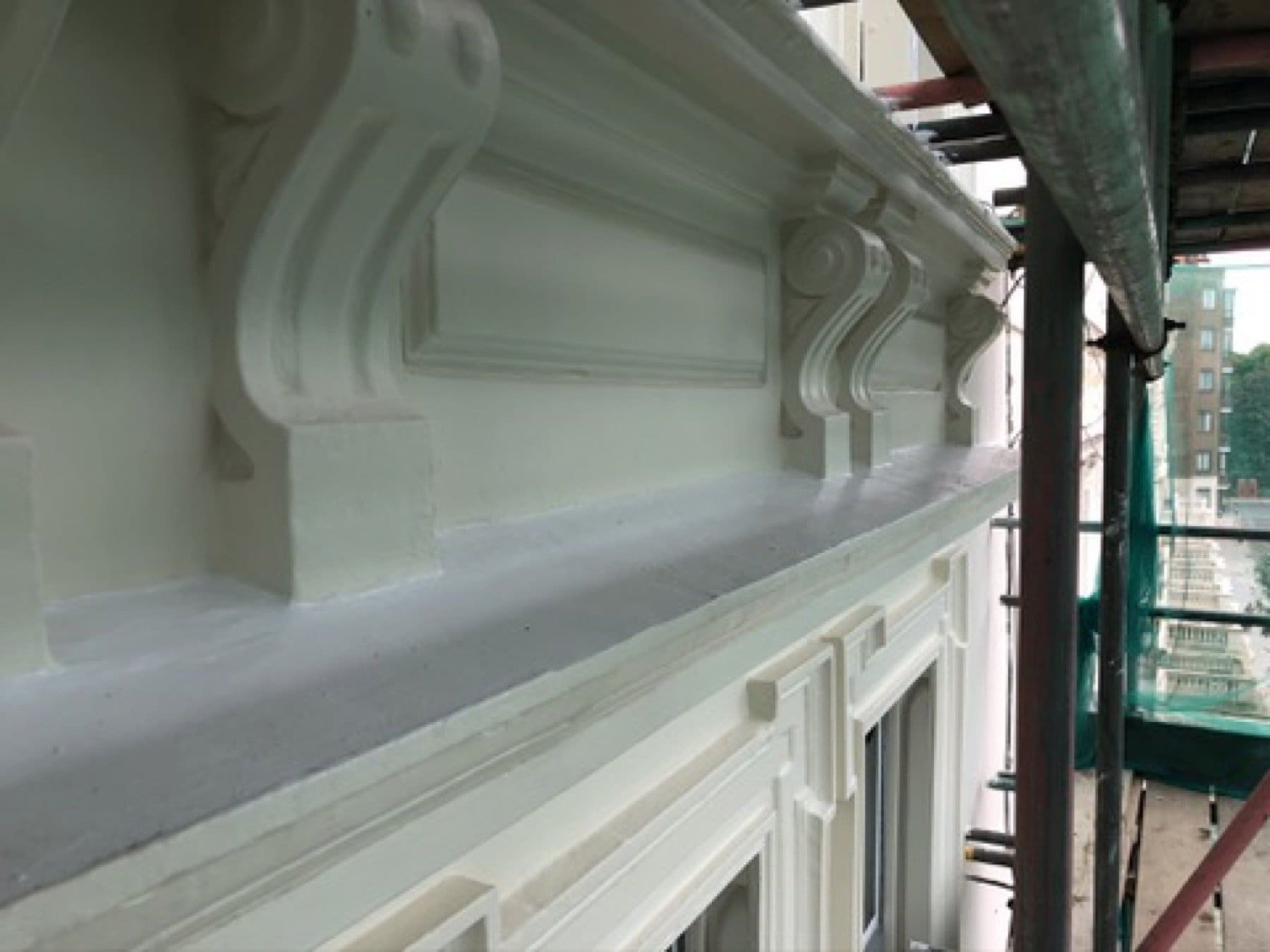 Inverness Terrace front under scaffold netting, with a columned entrance, balconies and sash windows.
