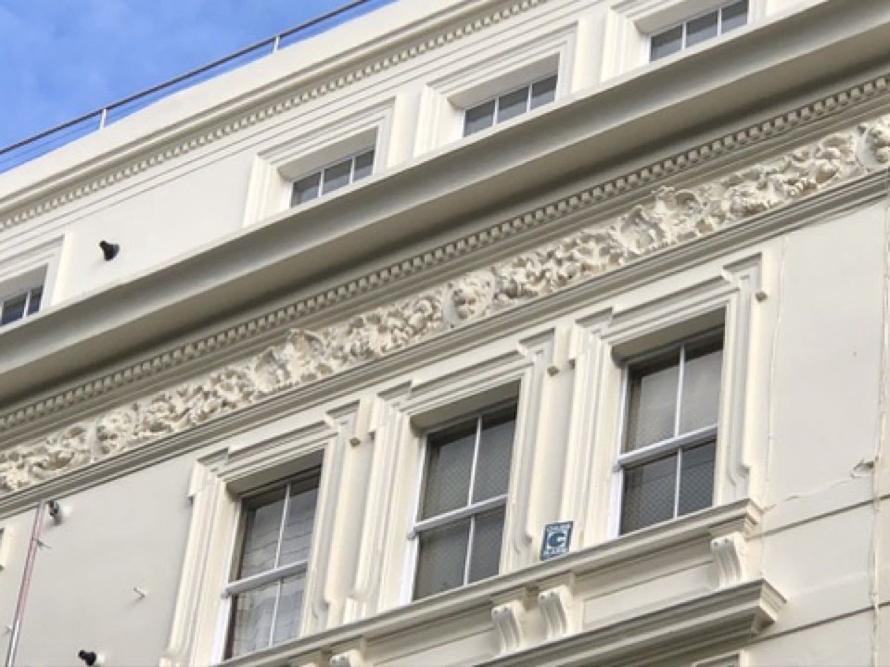 Finished white stucco frieze and sash windows on Inverness Terrace, Bayswater, with the scaffold down.