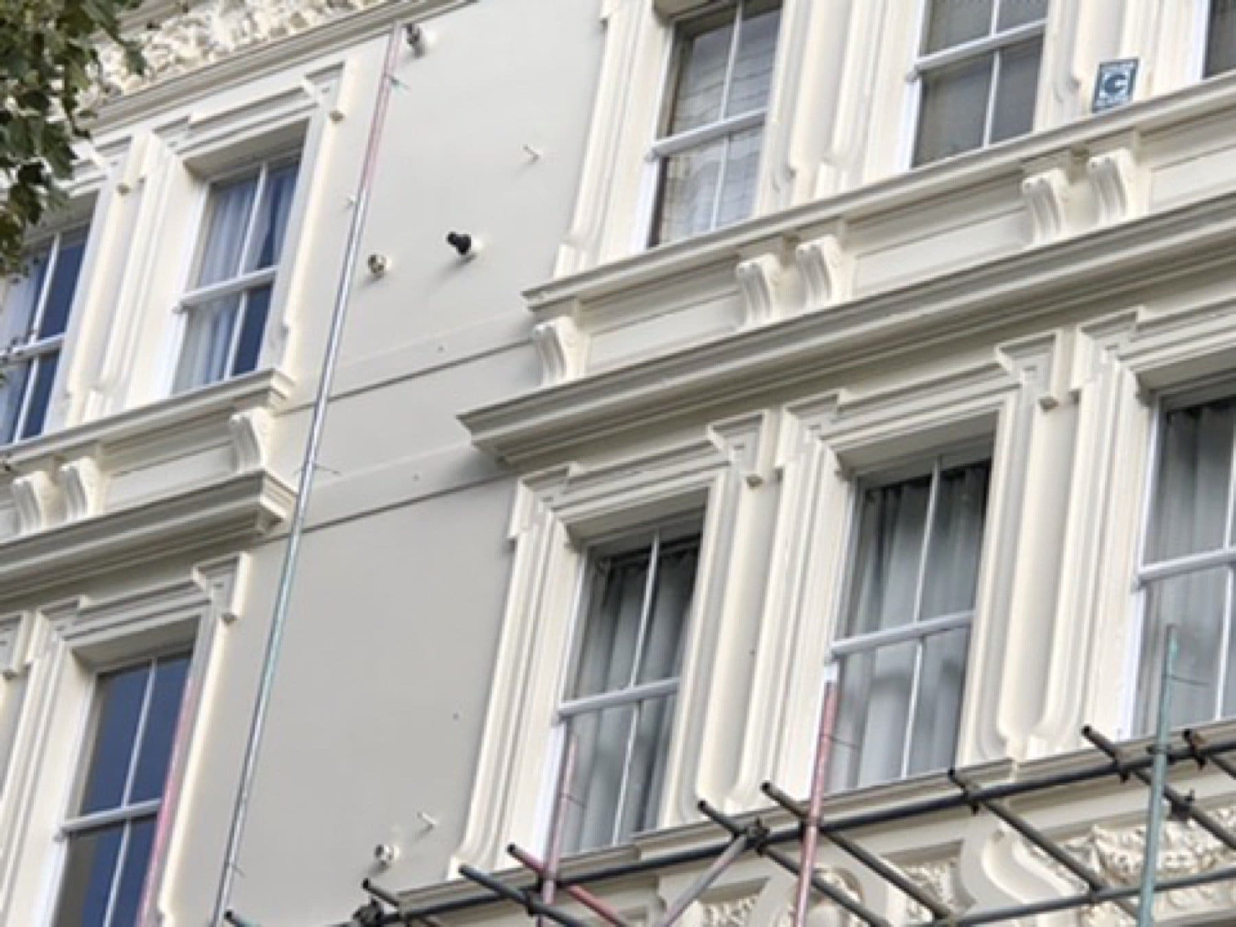 Inverness Terrace front with balconies and sash windows, scaffold still on the facade.
