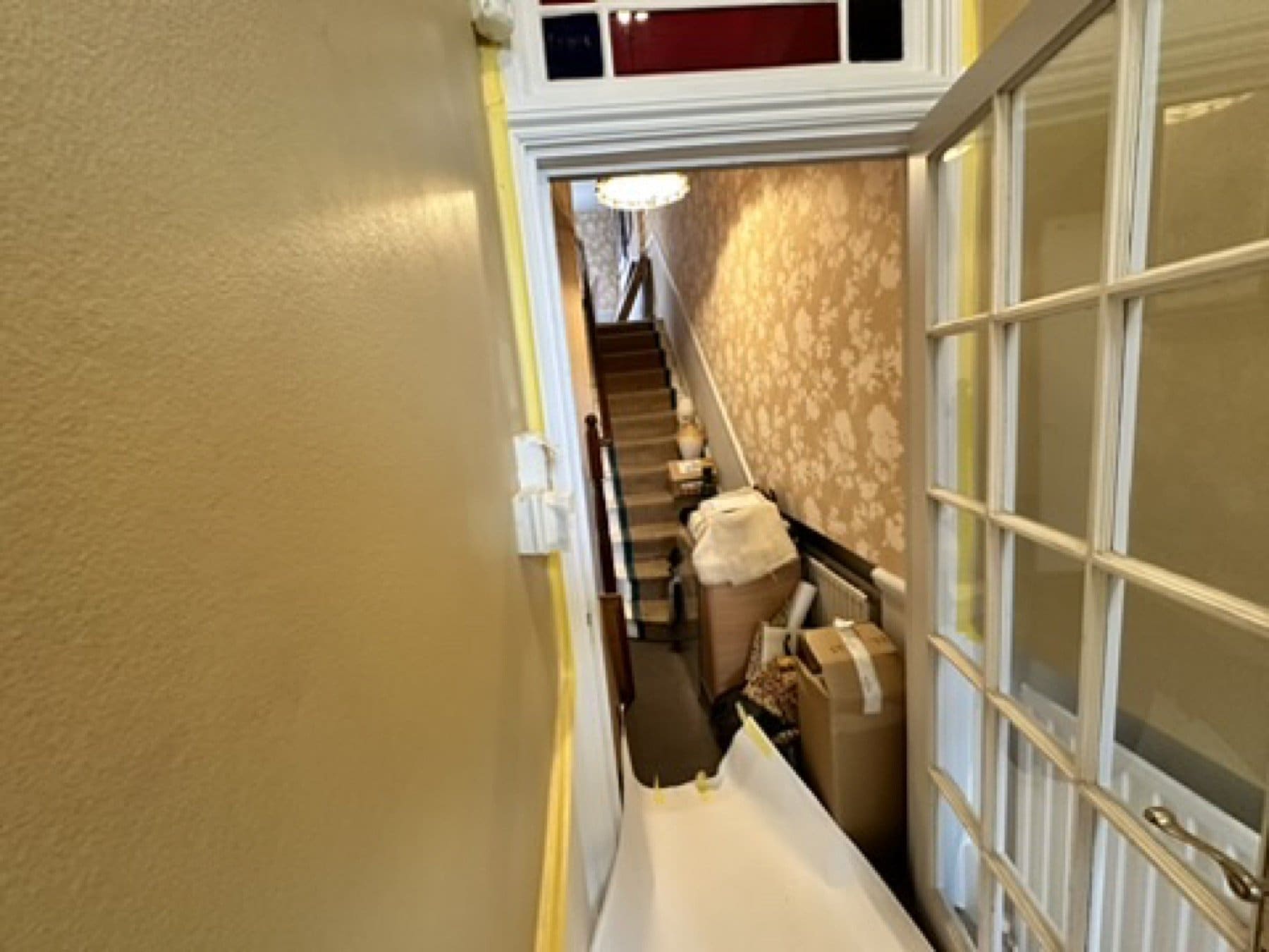 Stair hall at the Penny Morrison showroom, lined with a scenic landscape wallpaper.