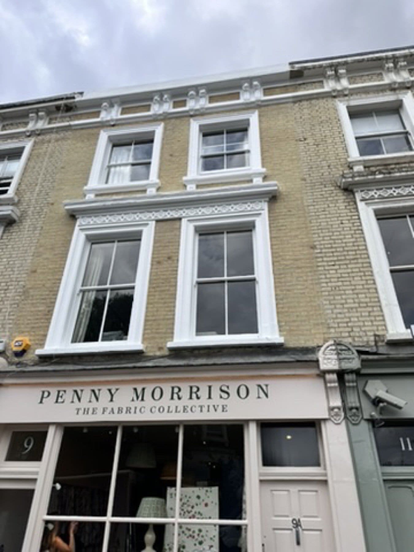 Brick and stucco bay of the Penny Morrison showroom, with sash windows.