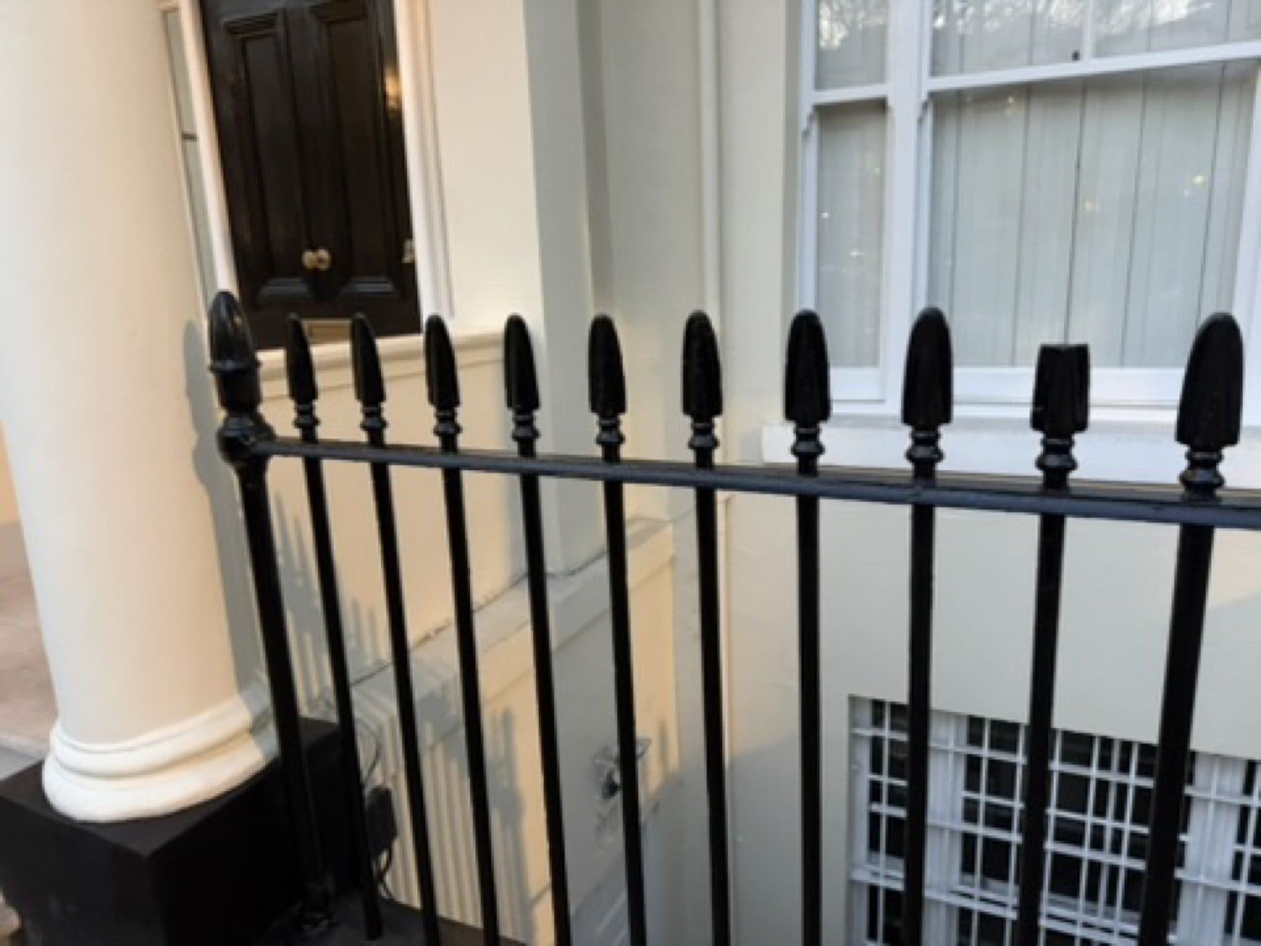Finished white columned entrance and black railings on St George's Square, Pimlico, with the scaffold down.