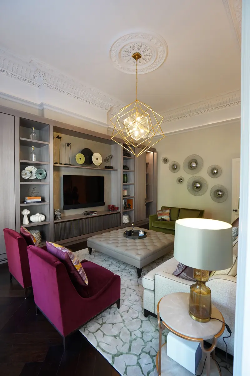 Upright view of the drawing room: pale textured walls beneath an ornate plaster cornice and ceiling rose.