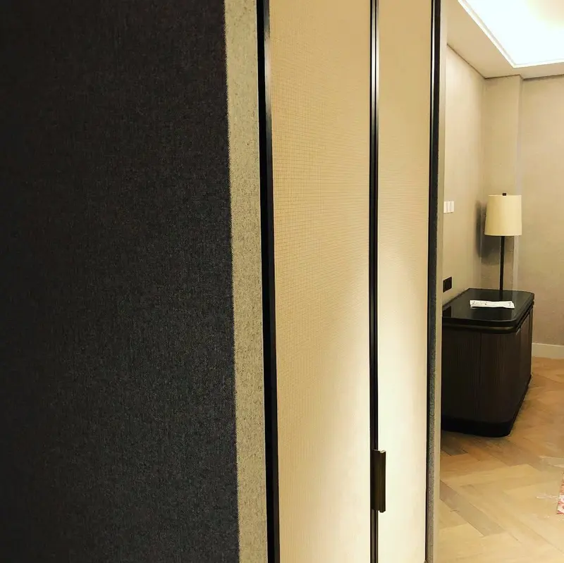 Hotel guest room corridor with textured neutral wallcovering and dark timber door frames, the Millennium Hotel, Grosvenor Square, now The Biltmore Mayfair.