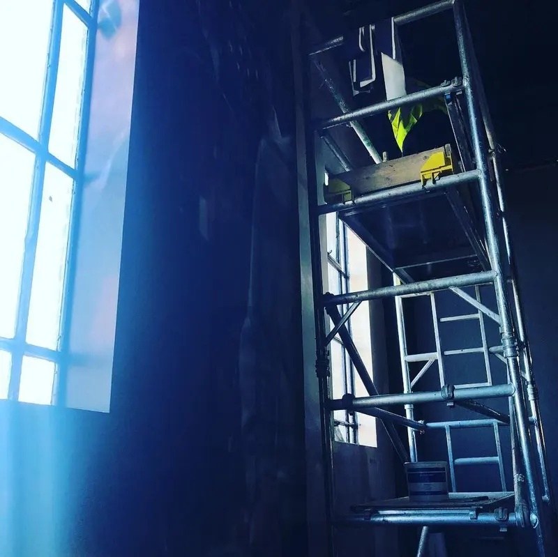 Mobile scaffold tower beside a tall window during mural installation at the Everyman cinema, Liverpool.