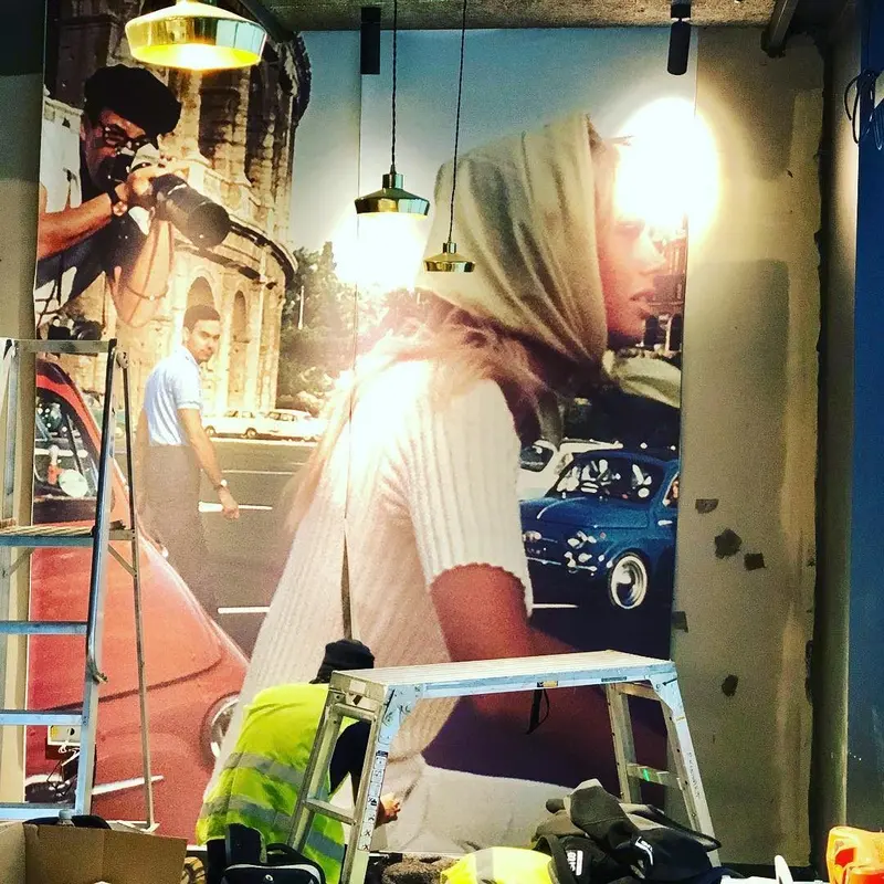 Wide view of the street-scene mural with installers at work, Everyman cinema, Liverpool.