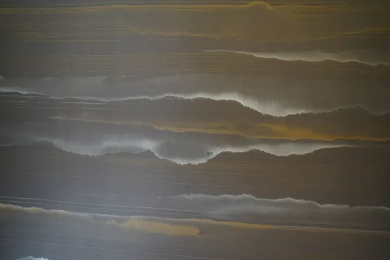 Close detail of the entrance-hall wallcovering: soft horizontal bands of charcoal, silver and ochre, laid with no visible seam.