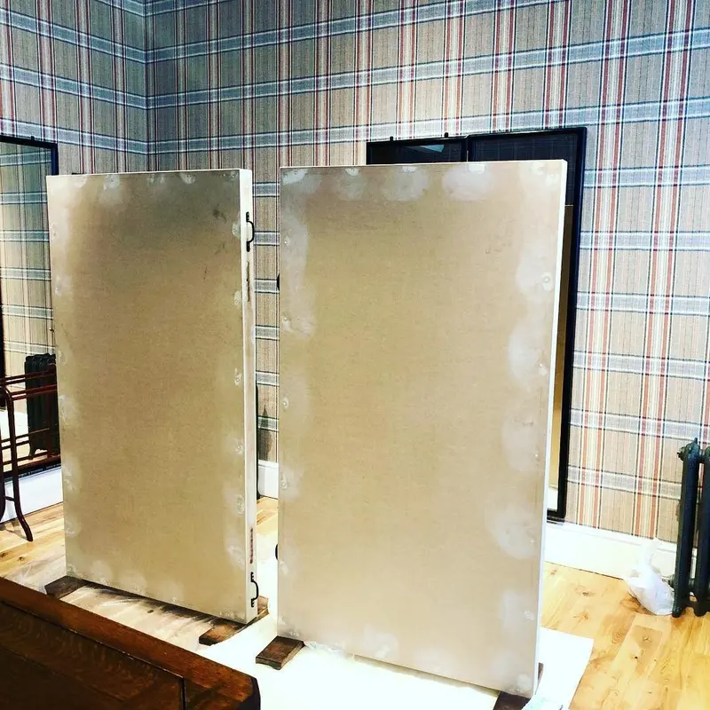 Pair of freestanding display boards covered in Huntsman tweed-print wallpaper.