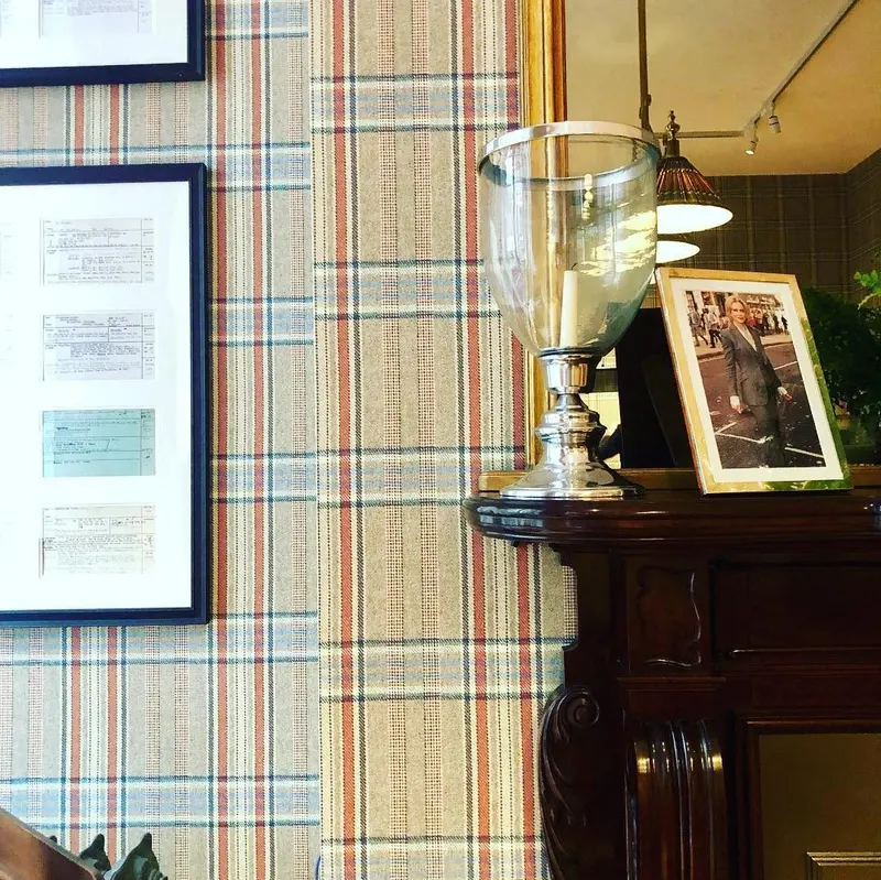 Huntsman, Savile Row: framed pictures on the bespoke tweed-print wallpaper.