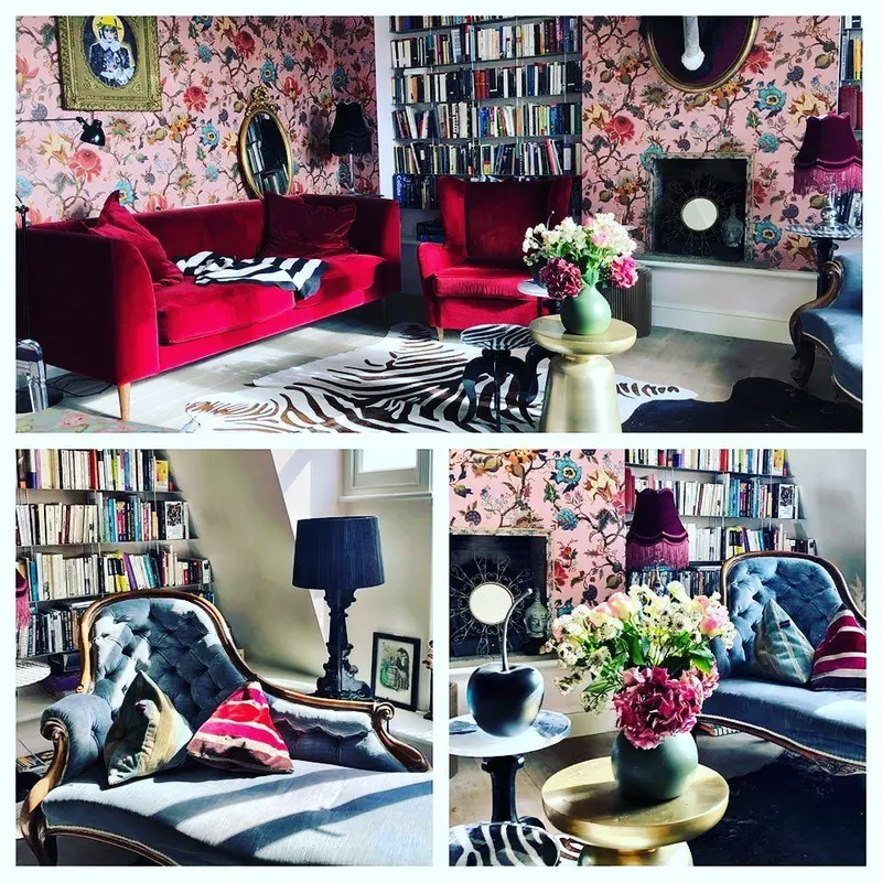 Living room in a private residence in Little Venice: a pink floral House of Hackney wallpaper, a red sofa and bookshelves.