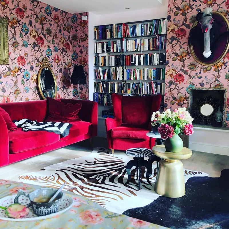 Floral-papered sitting room with a red velvet sofa and full bookcases, a private residence in Little Venice.