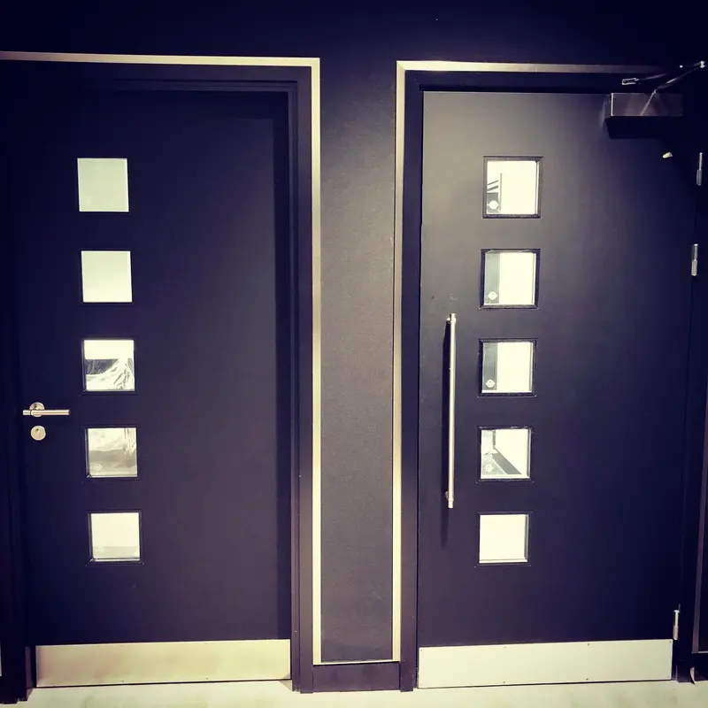 Two doors set in black matt wallcovering with narrow brushed-steel trims, Mercedes-AMG showroom, London.