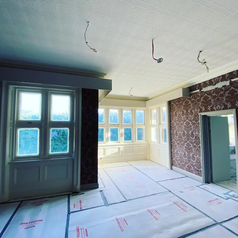 Pendley Manor bedroom with damask walls and bay window, mid-refurbishment.