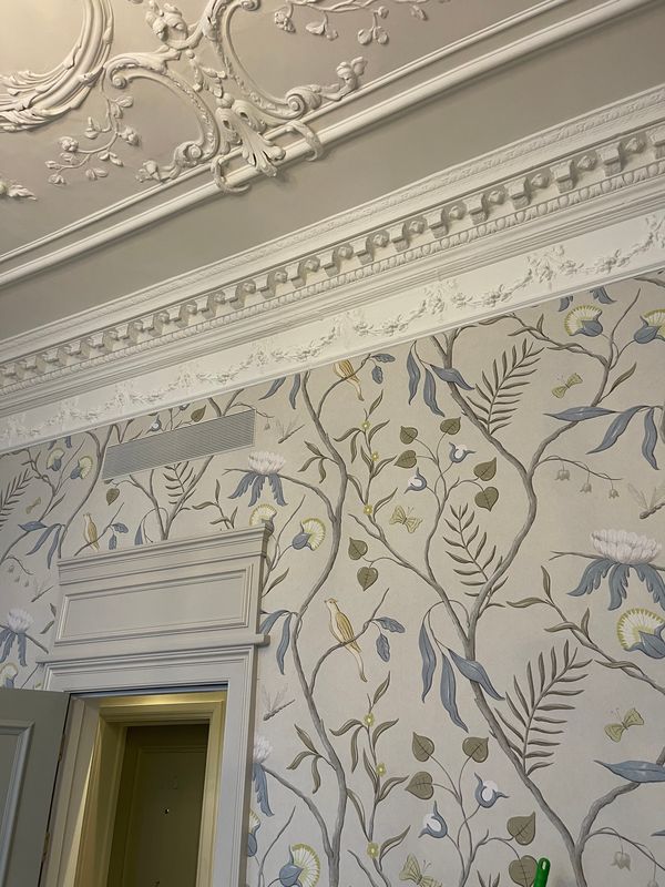 Adam's Eden wallcovering meeting a carved cornice and decorative plaster ceiling at Brown's Hotel, Mayfair, above a door case.
