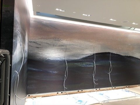 The long wall of the mural beneath the lit cove.