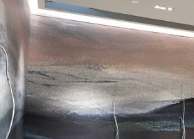 Detail of the mural meeting the lit cove at the top of the wall.