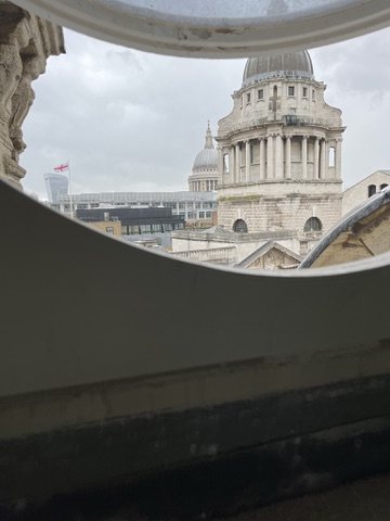 The dome of St Paul's Cathedral seen through a round window at 15 Old Bailey.