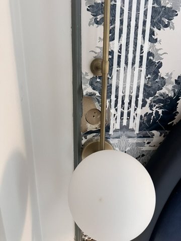 Detail of Totem Damask wallpaper beside a wall light.