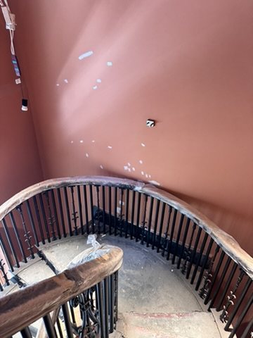 Stair landing with terracotta walls at Hyde London City.