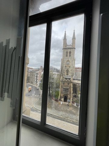 A neighbouring church tower seen from an upper-floor window.