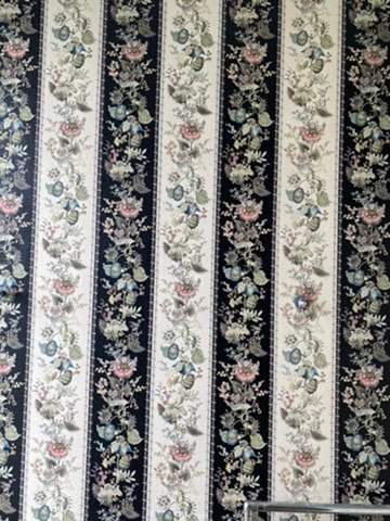 Close view of a dark floral stripe wallpaper hung at the Castle of Trematon.