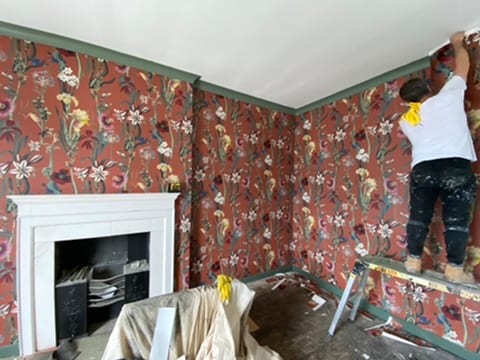 Terracotta floral wallpaper being hung at the Castle of Trematon.