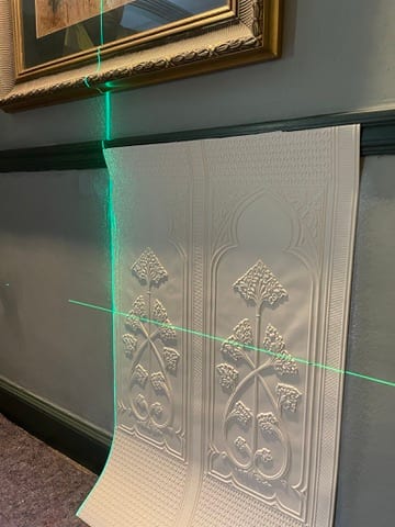 Lincrusta relief wallcovering hung to a laser line at the Castle of Trematon.